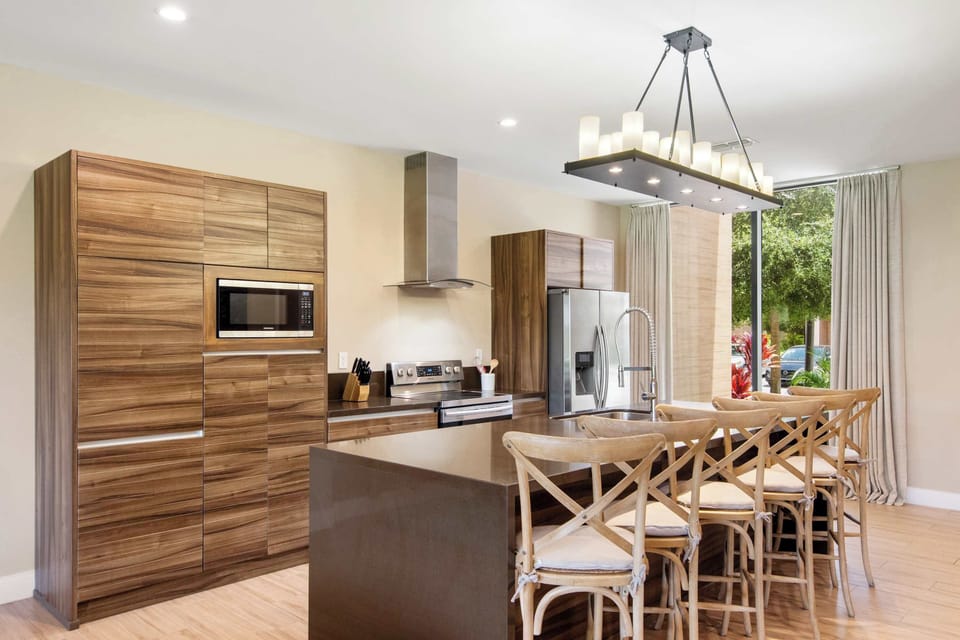 Custom wood cabinetry, large island, and modern lighting define this space.