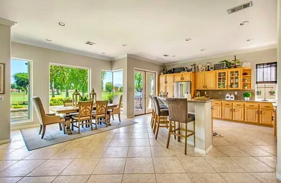 Open kitchen and dining with golf course views and bright light.