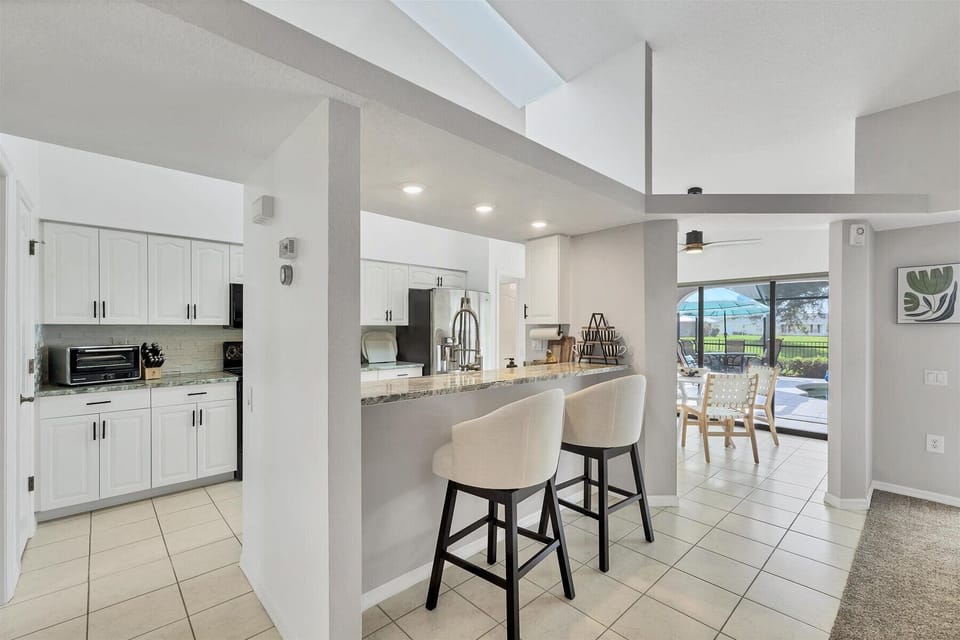 Bright, open kitchen with bar seating and a view straight to the pool.