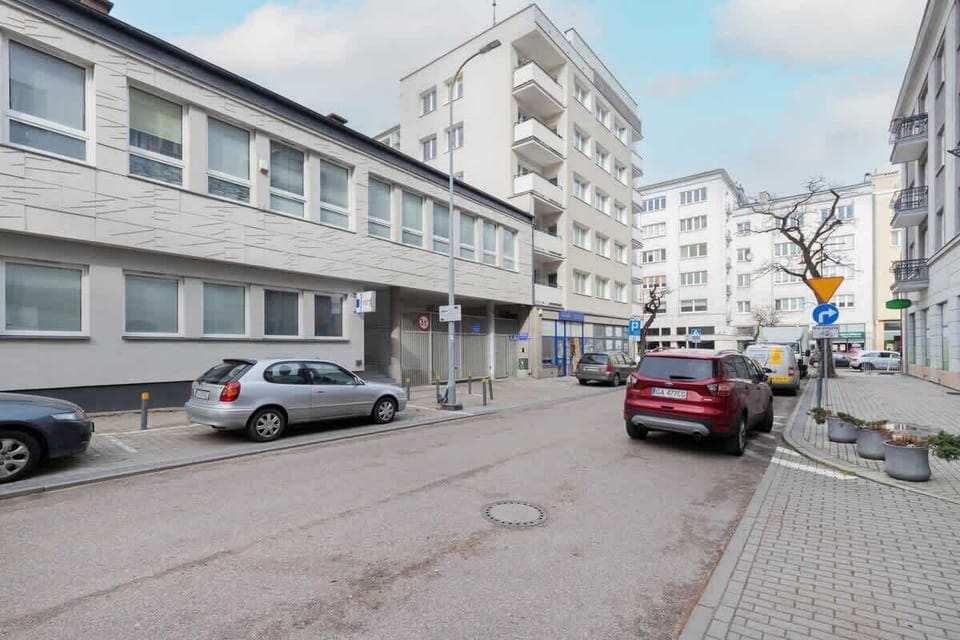 An exterior view of the building located in a quiet urban area with street parking.
