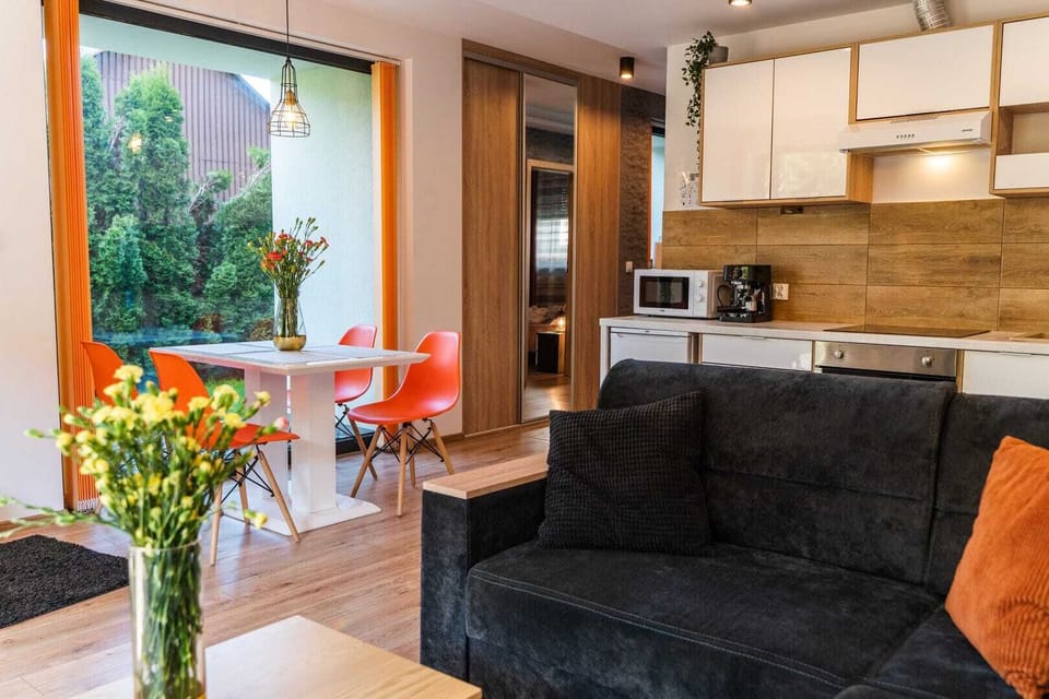 Living room with gray sofa, wall-mounted TV, and access to a terrace.
