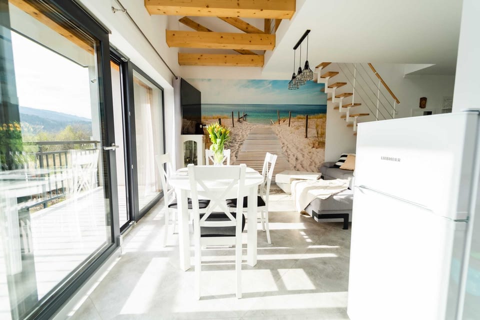 Living room with a sofa bed, TV, kitchenette and dining area.