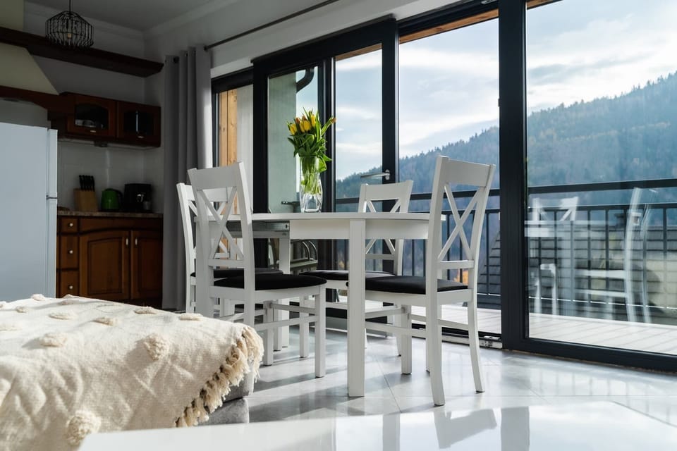 Living room with kitchenette and dining area with exit to balcony.