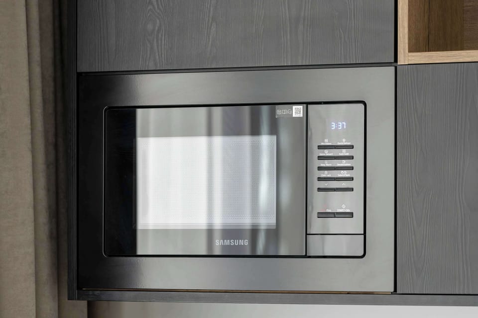A close-up of a sleek built-in microwave in the kitchen with contemporary cabinets.