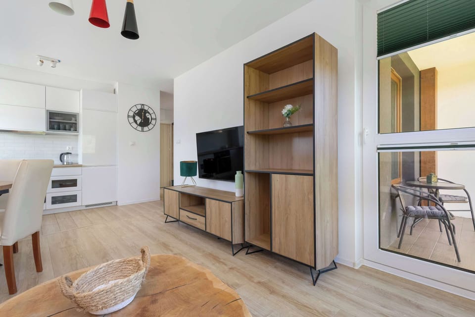 Modern living room with a sofa, coffee table, TV and access to balcony.