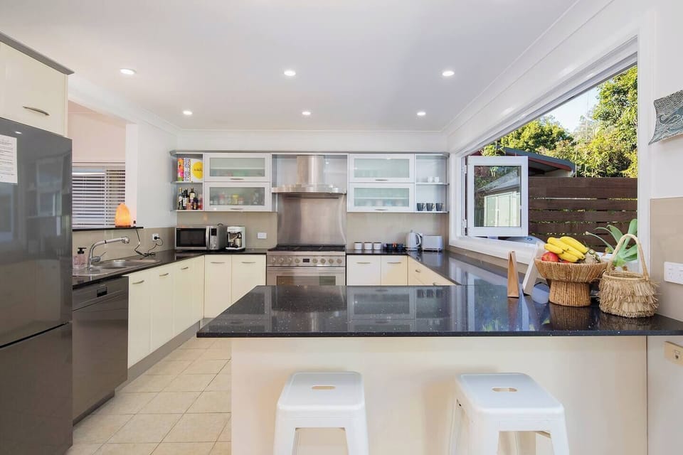 This kitchen includes stone benchtops, modern appliances and an espresso machine for your morning ritual.