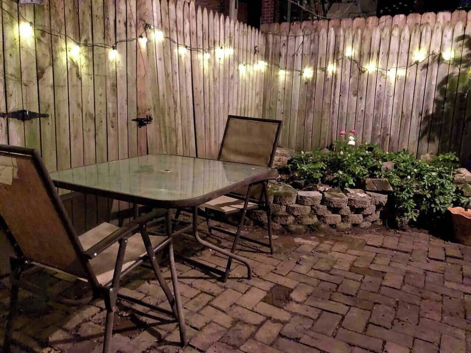 Lovely brick patio with water feature and cafe lights. 