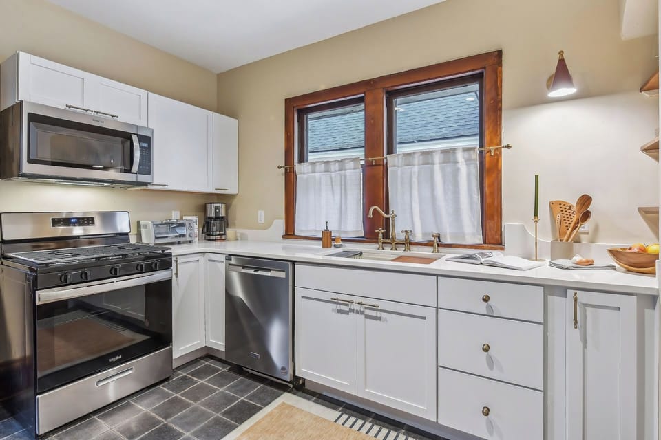 Tiled kitchen with stainless steel appliances and new quartz countertops.