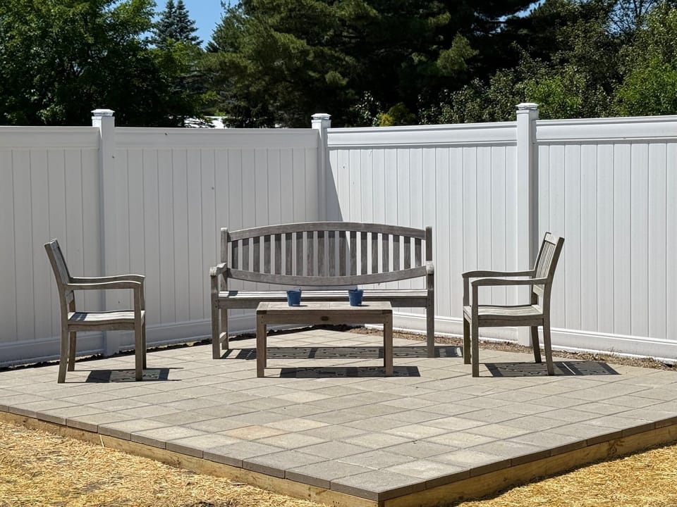 Private backyard oasis with teak furnishings and a brand-new fenced patio.