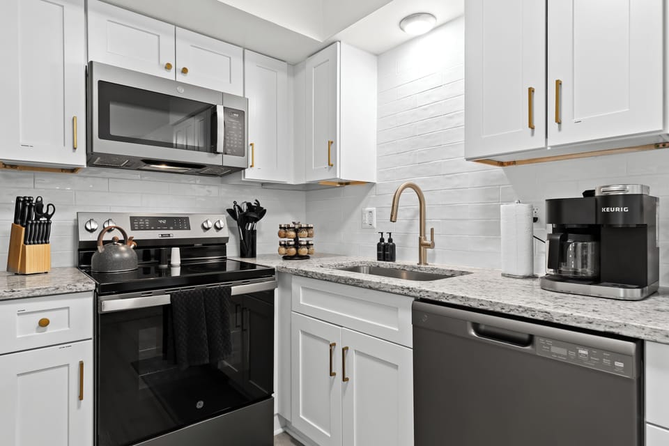 Sleek kitchen featuring stainless steel appliances, granite countertops, and a Keurig coffee maker.