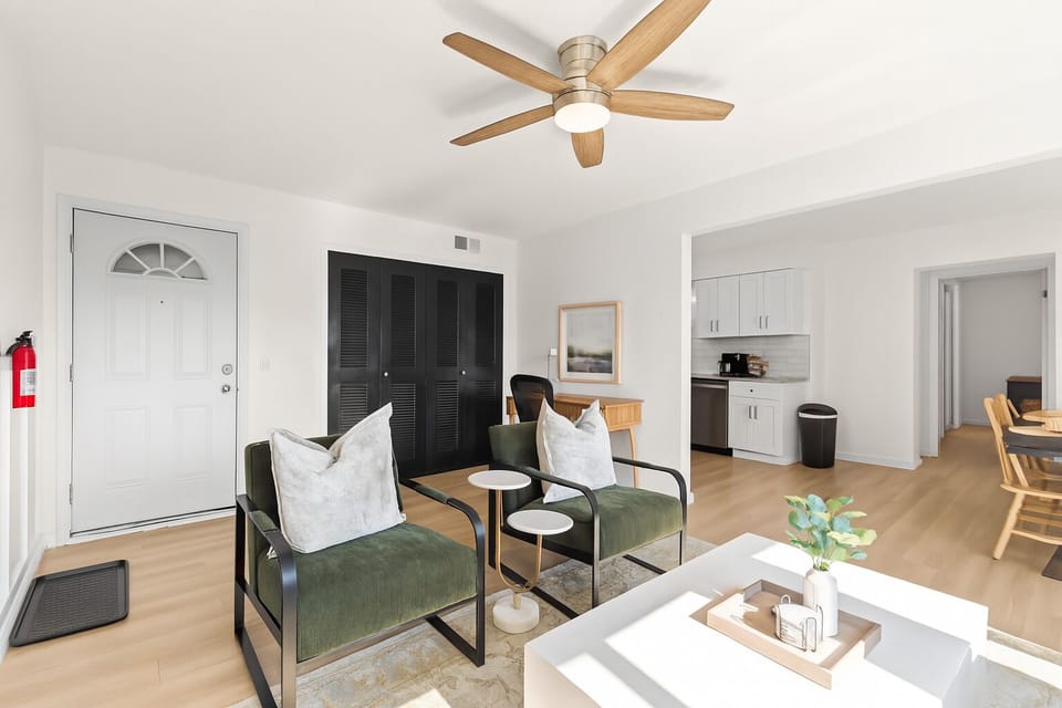 Open-concept living and dining area with ceiling fan, stylish accents, and plenty of natural light.