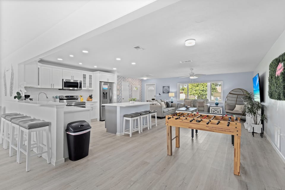 Enjoy the open-concept kitchen and main living area, where modern amenities meet fun with a foosball table for endless entertainment.
