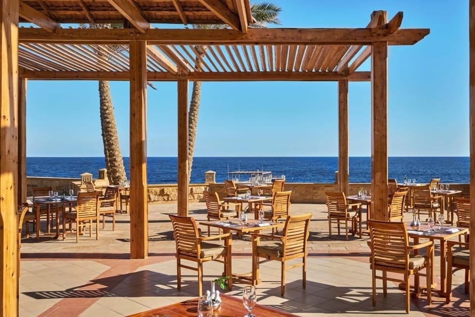Linger over brunch on an oceanfront terrace under blue skies.