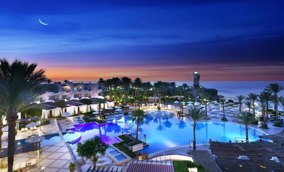 Sip and swim as sunset colors glow over illuminated pools.