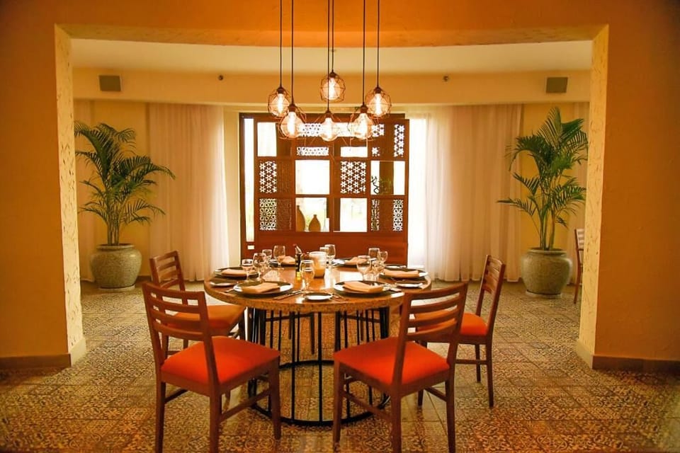 Gather for elegant dinners beneath warm lighting and palms.
