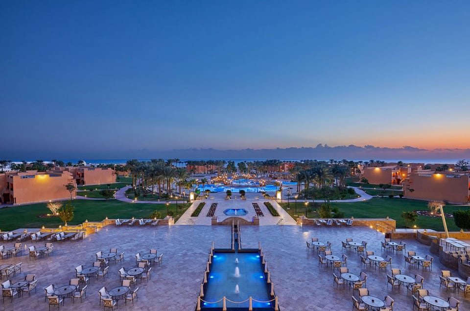 Unwind at dusk as lights shimmer across the courtyard pools.