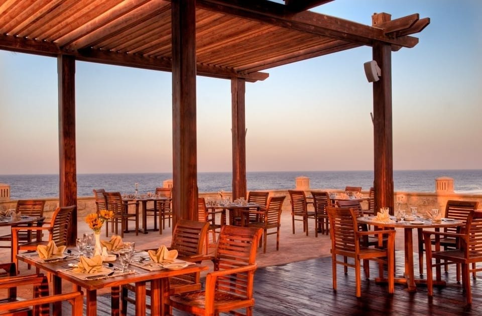 Dine seaside at sunset as ocean breezes cool the evening.