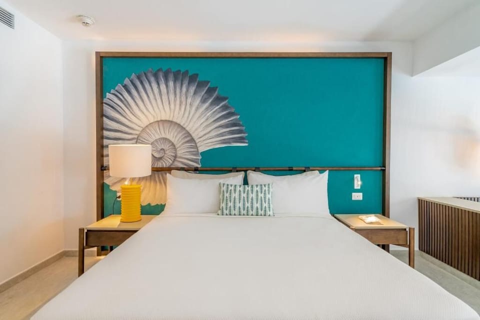 Unwind in crisp linens beneath bold, resort-chic artwork.