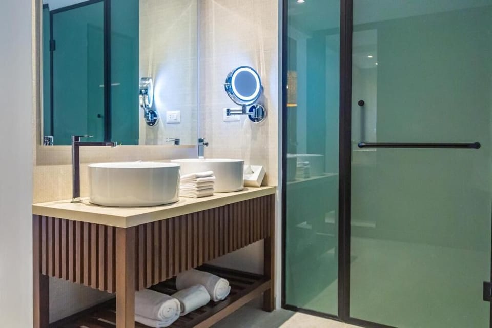 Refresh easily with a sleek vanity, bright mirror, and glass shower.