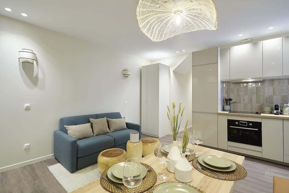 Salon avec espace repas, cuisine et canapé lit