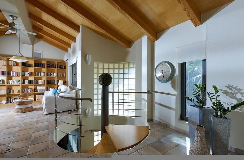 Loft Lounge with Built-in Library and Sea View
Relax and read in a bright space with wooden ceilings and a scenic backdrop.