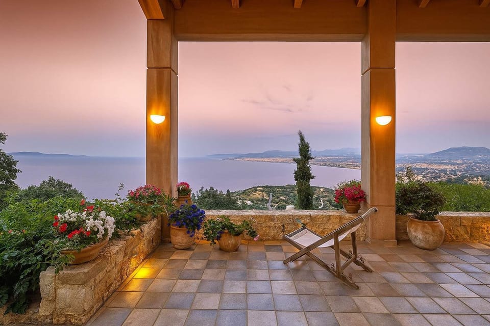 Sunset Terrace with Dining Area and Expansive Sea View
Warm, golden-hour lighting frames this inviting covered terrace with rustic dining setup and captivating views across the bay.