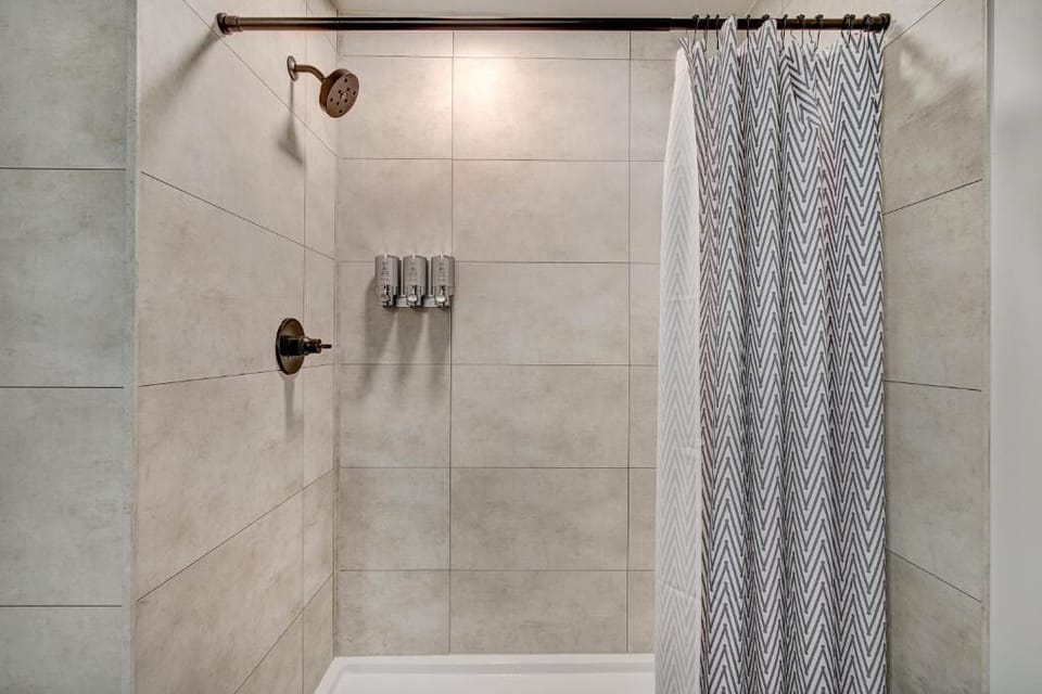 Rinse off under the rainfall shower in a tiled retreat.