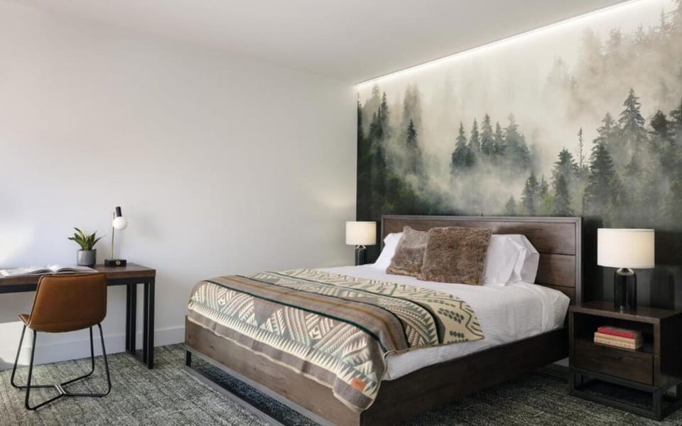 Unwind in a cozy bed framed by a dramatic mural.