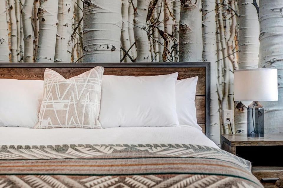 Sink into crisp bedding against a warm, nature-inspired headboard.