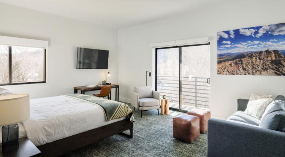 Unwind in a sunlit bedroom with cozy lounge seating.