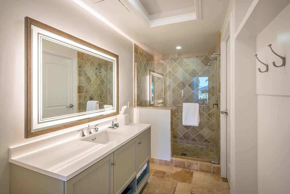 Begin and end your day with ease in a refreshing bathroom retreat framed in soft lighting and natural stone.