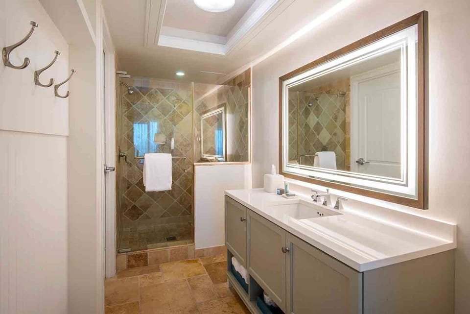 Refresh with ease in a beautifully lit bathroom where natural stone and clean design set a tranquil tone.