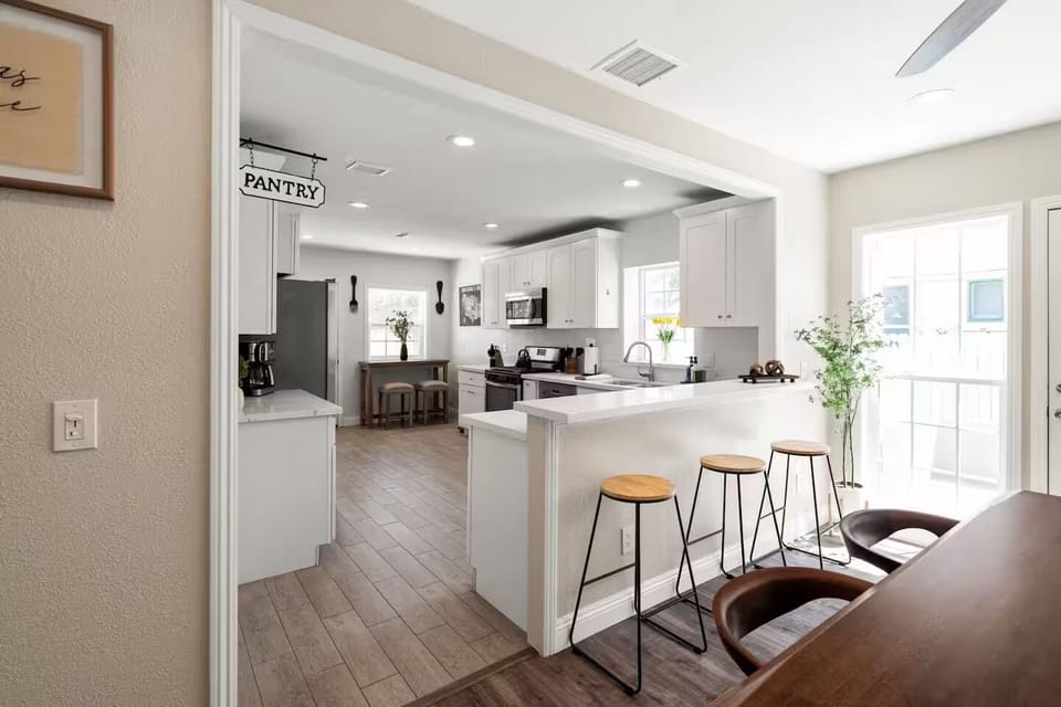 Modern kitchen with pantry access, sleek finishes, and cozy dining space nearby.