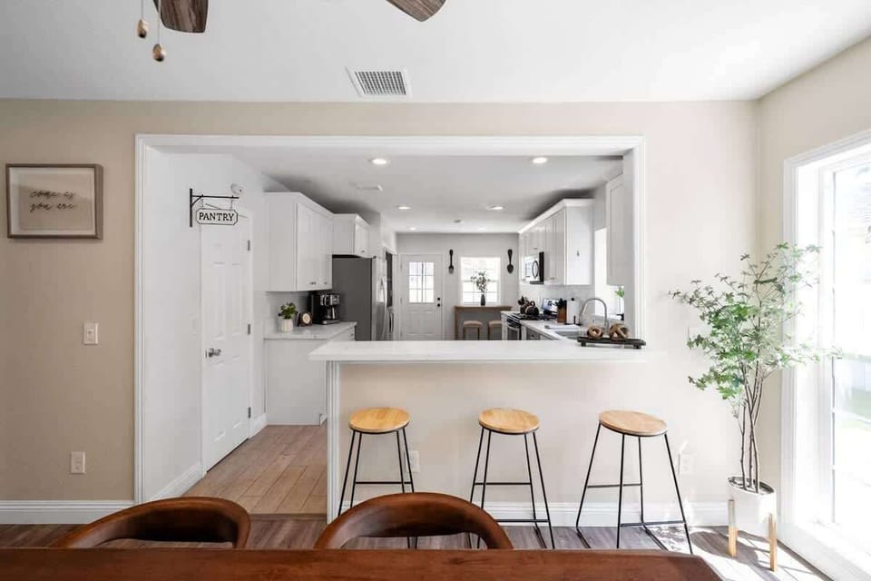 Open kitchen layout with counter seating and natural light from large window.