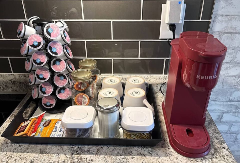 Coffee maker, premium coffee blends, tea varieties, sweeteners, cream (in fridge)