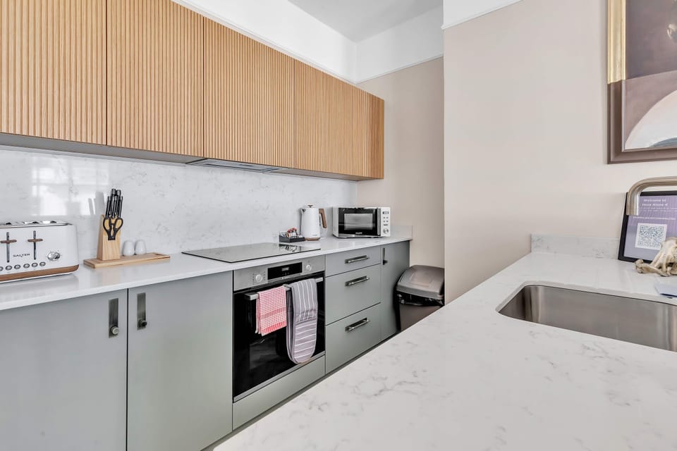 Stylish kitchen area featuring electric hob, oven, dishwasher and ample counter spac