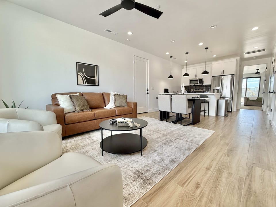 Bright open-concept living with comfy seating, modern kitchen & dining — perfect for relaxing after exploring Southern Utah.