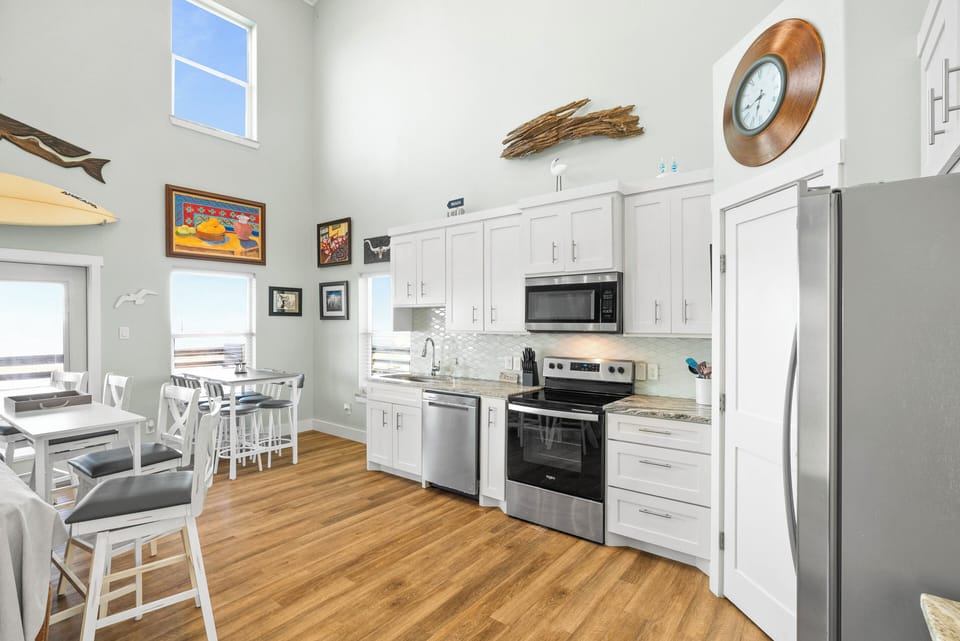 Fully equipped kitchen with modern appliances and coastal decor.