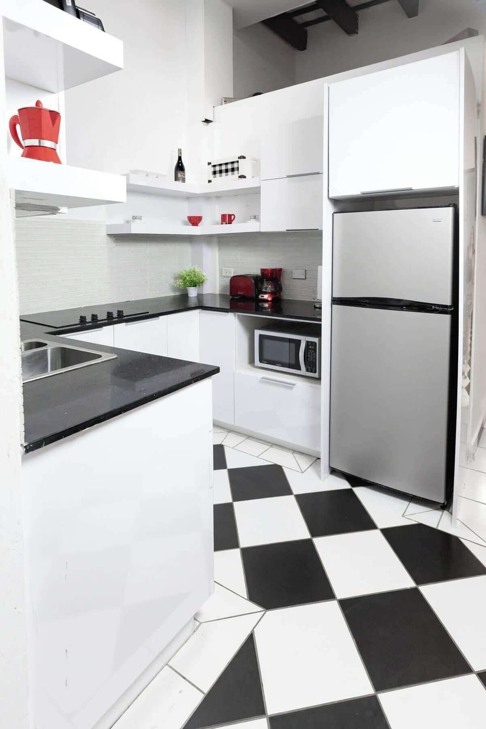 Cook and dine with ease in the modern and well-equipped kitchen. The clean and stylish checkered floor tiles, ample counter space, and stainless steel appliances make meal preparation a delight during your stay.