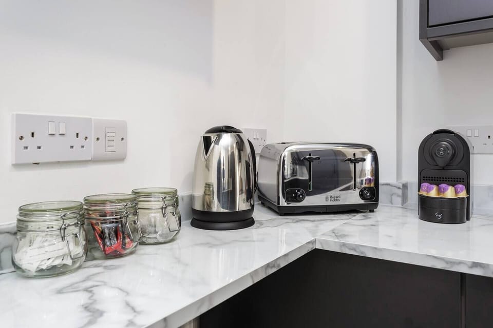 Black cabinets, sharp lines, and your morning brew on tap – this kitchen means business.