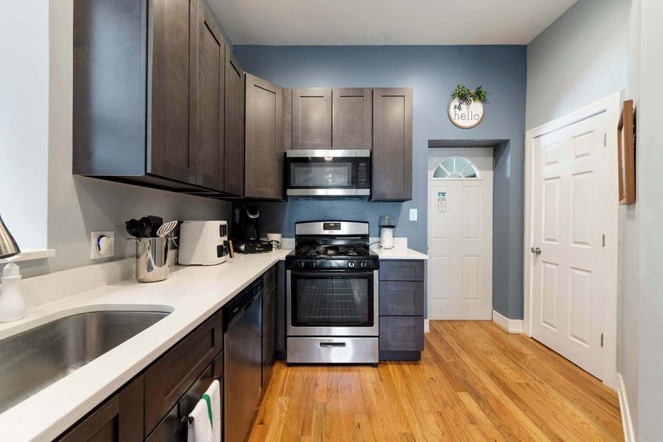 Modern kitchen layout w/ full-size fridge and ample cabinetry for storage