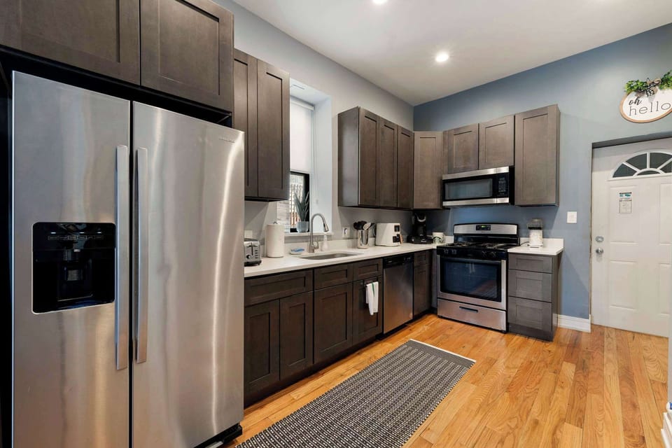Contemporary kitchen view w/ stainless appliances and streamlined counters