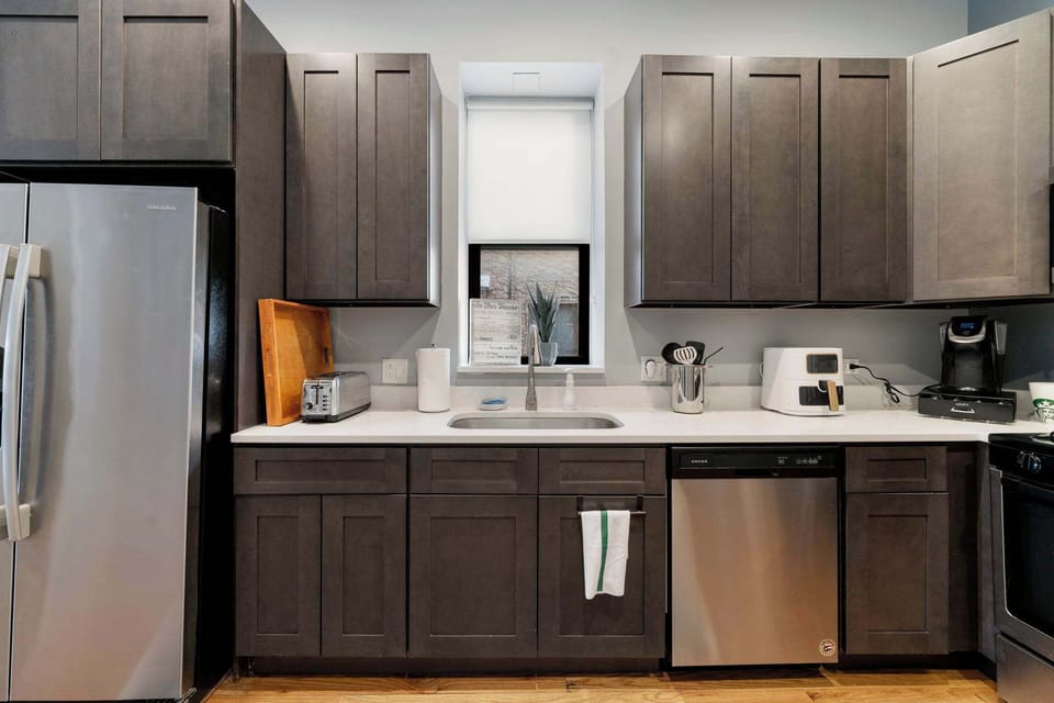 Modern kitchen layout w/ full-size fridge and ample cabinetry for storage