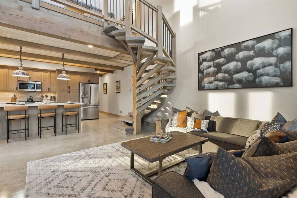 Claim your spot on the sectional under the big bison print and let the spiral staircase framing pull your eye up to the loft above.