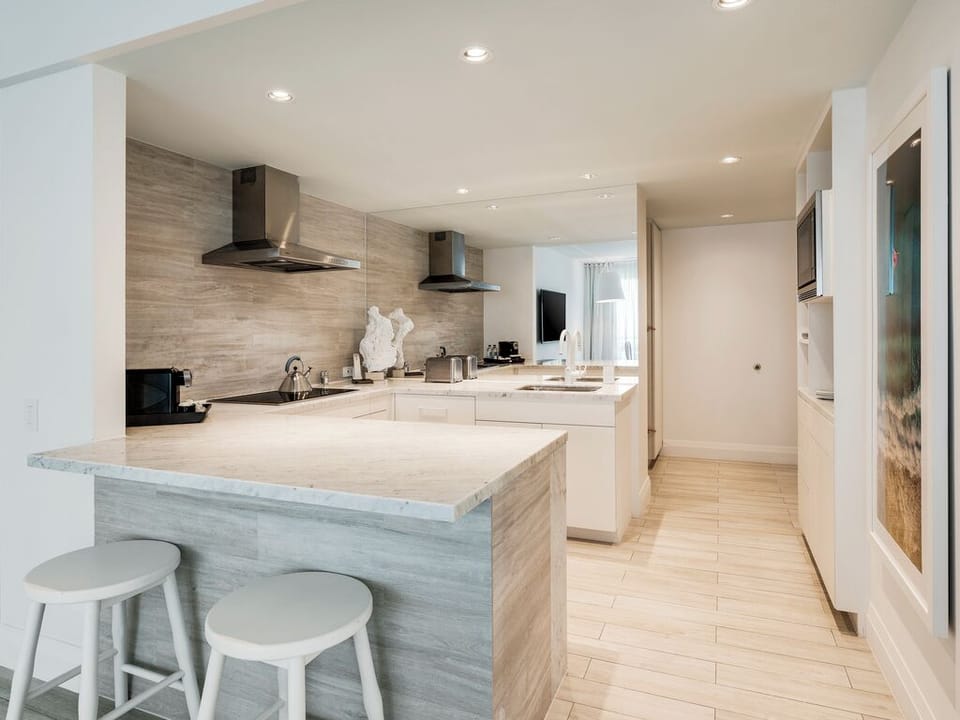 Cook together in a sleek kitchen with spacious stone island.