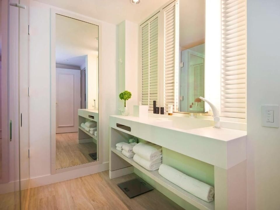 Refresh in a spotless vanity area with neatly stacked towels.