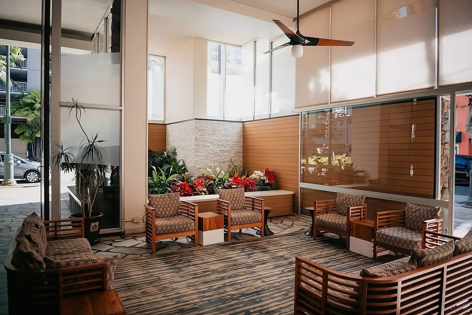 Relax among lush greenery in a sunlit indoor lounge.