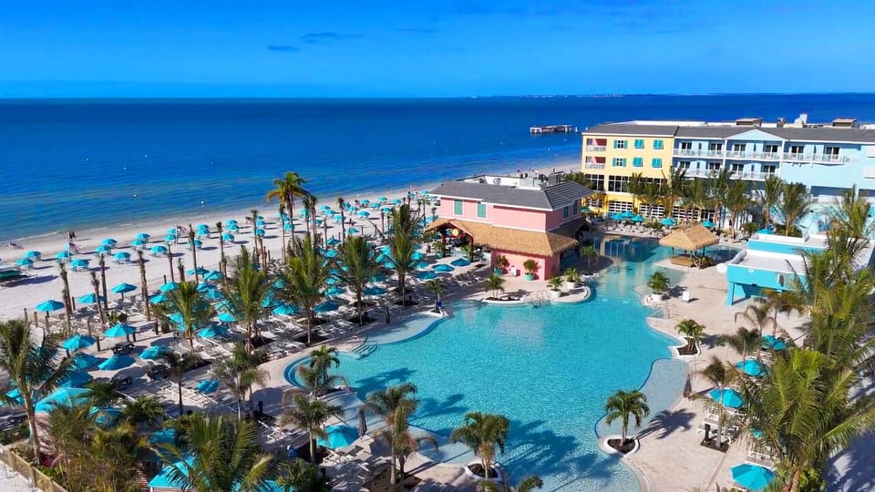Dive into turquoise pool bliss beside endless white-sand beach.