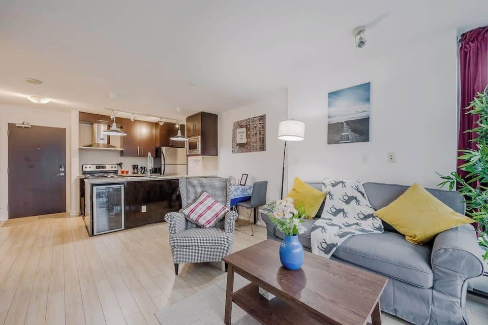 Charming dining area with seating for two, adjacent to the fully equipped kitchen. Features granite countertops and convenient microwave. Ideal for intimate meals. Contemporary art and a statement floor lamp add character.