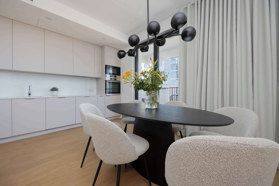 A neat kitchen and living room combo with subtle colors and modern furniture, perfect for compact yet stylish living.